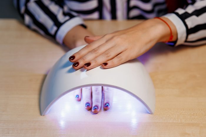 pretty girl dry your nails in the UV lamp