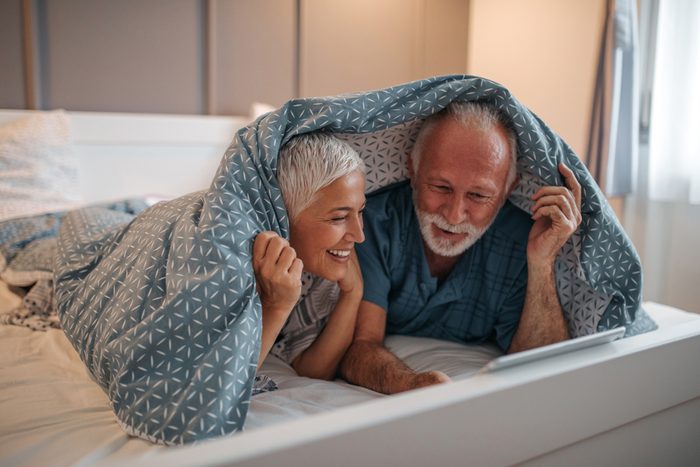 Senior couple using tablet in bed