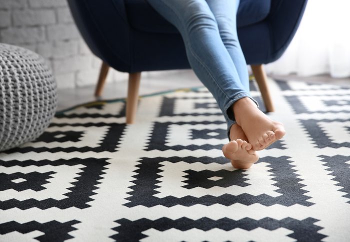 Woman sitting in chair with bare feet on carpet