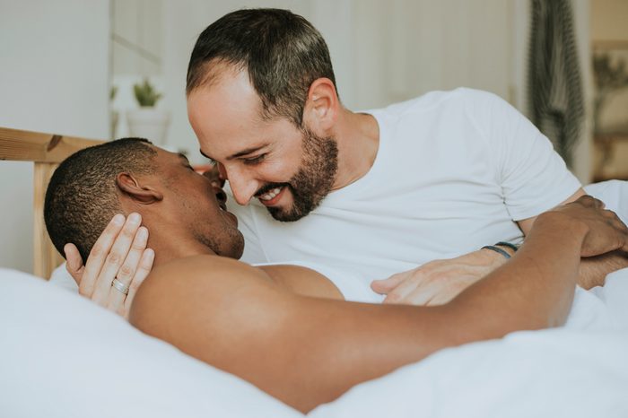 Gay couple making out in bed