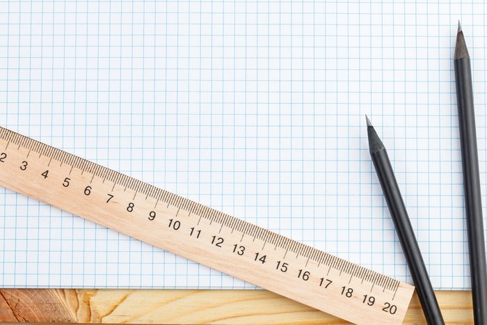 An open notebook and a ruler with two pencils on a wooden background. Office or school supplies, training, planning, office, freelance staff