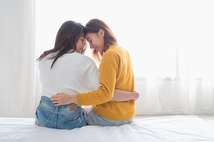 Asia lesbian lgbt couple hug and sitting on bed near white window with happiness moment together,love wins concept