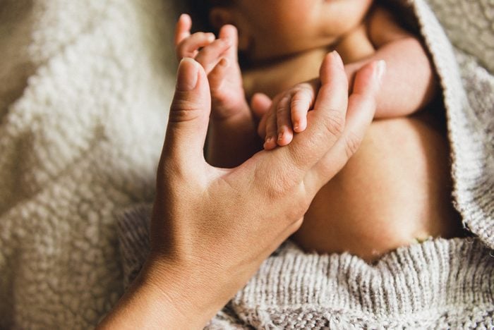 Newborn baby hand holding mother Finger