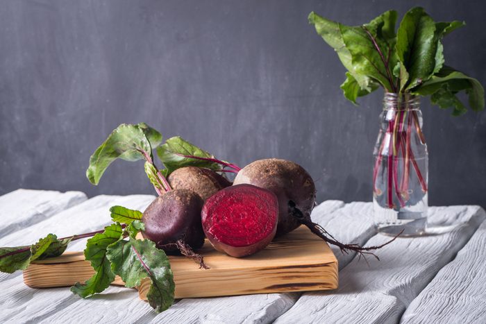 Beetroots on white painted rustic wooden table with slate background.