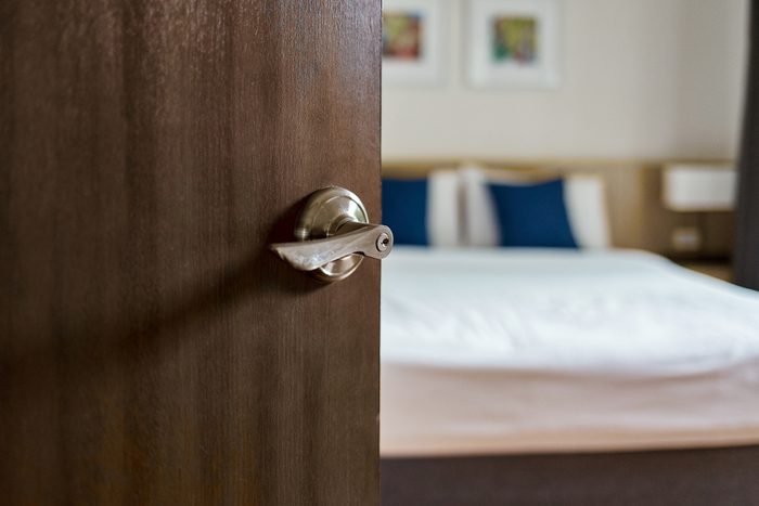 Hotel room interior, Condominium or apartment doorway with opened door in front of blur bedroom background