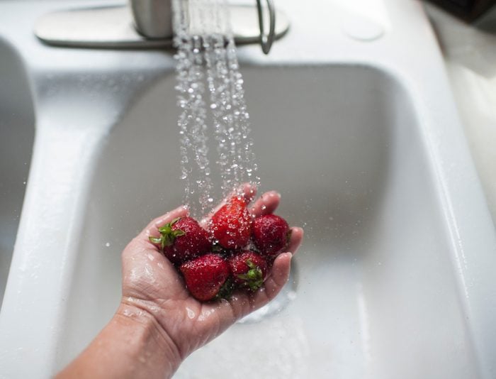 washing strawberries in sink