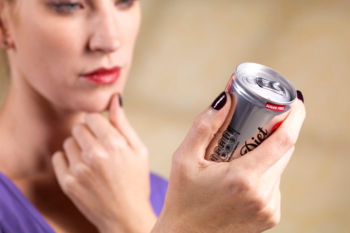 woman looking at diet coke can