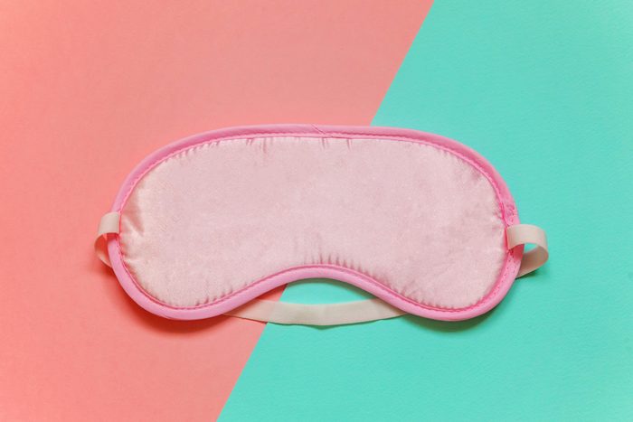 Sleeping eye mask, isolated on pink and blue pastel colourful trendy geometric background. Do not disturb me, let me sleep. Rest, good night, insomnia, relaxation, tired, travel concept