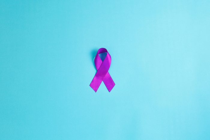 Purple ribbons on blue background, Alzheimer disease, Pancreatic cancer, Epilepsy awareness, domestic violence awareness,fibromyalgia awareness, world cancer day. copy space
