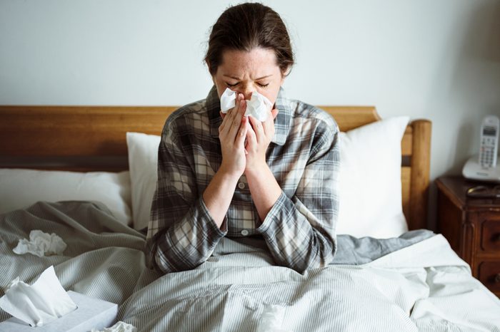 A woman suffering from flu in bed