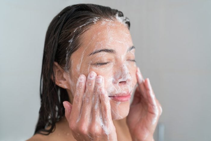 woman washing face with foaming facewash