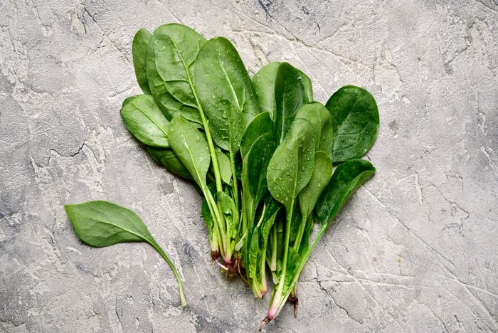Fresh spinach leaves on a light grey slate, stone or concrete background.Top view with copy space.
