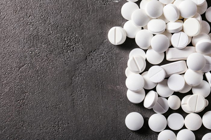 White pills on grey textured background