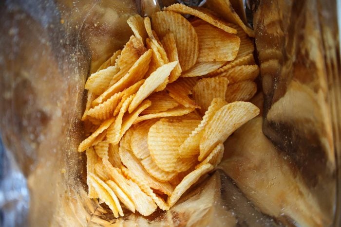 Potato chips in open snack bag close up