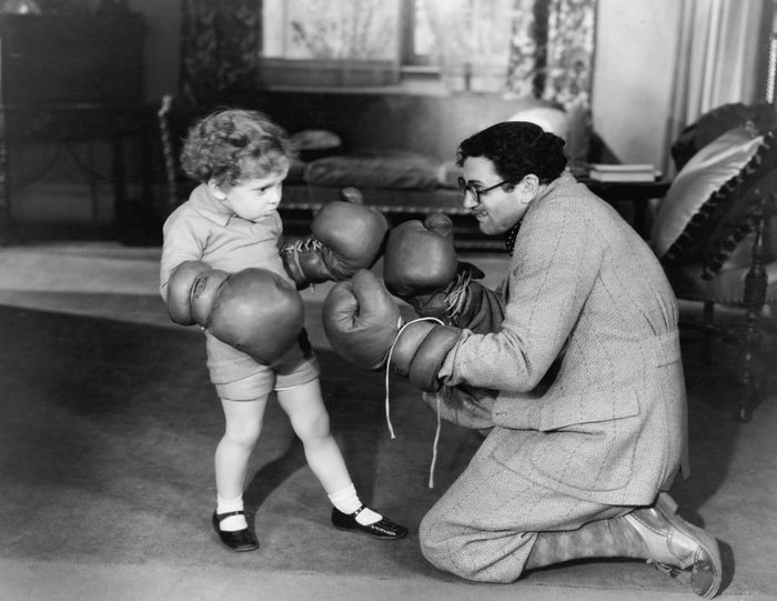 Father and young son playing with boxing gloves