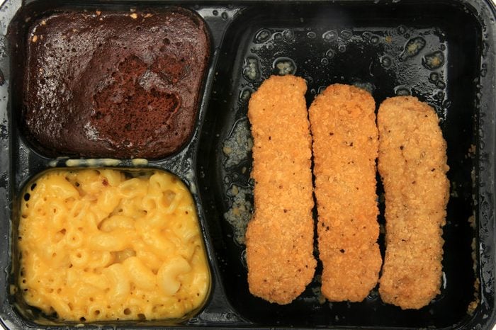 frozen microwaveable "tv dinner" "Chicken Fingers Meal" with "Breaded Chicken Patties", "Macaroni & Cheese Sauce", and a "Fudge Brownie" isolated on white with room for your text