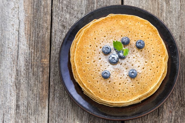 crepes with fresh blueberries on wooden table, top view, horizontal