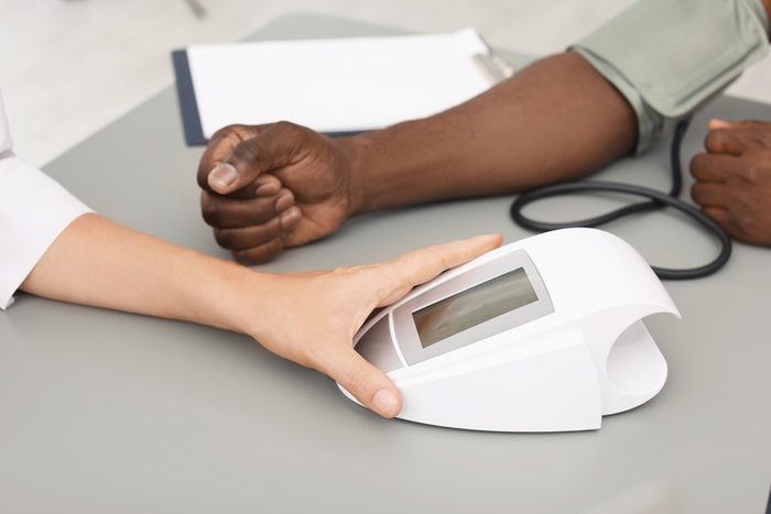 doctor or nurse checking patient's blood pressure