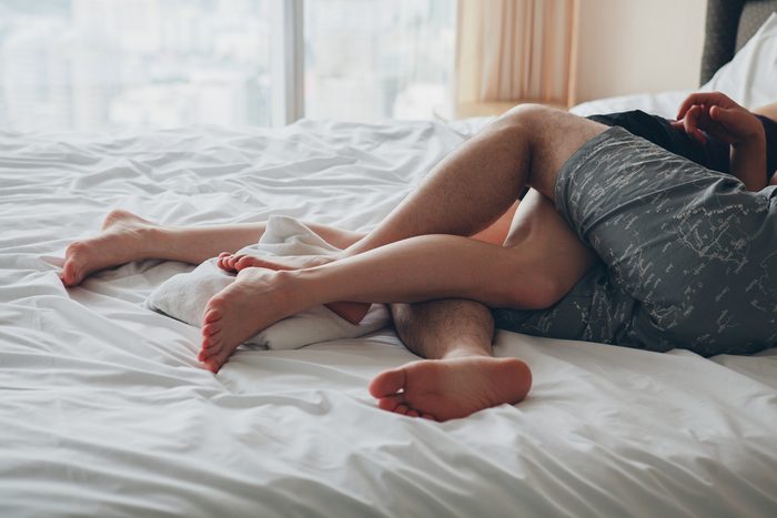 couple with tangled legs in bed