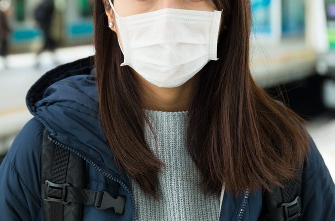 Woman wearing face mask at train station