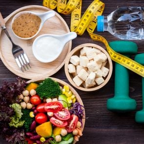 fresh vegetables, tofu, measuring tape, weights, and watter; weight loss concept