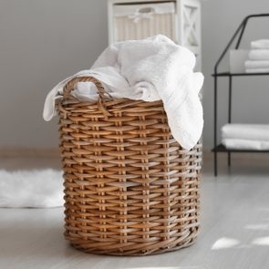 Laundry basket with dirty towels on floor