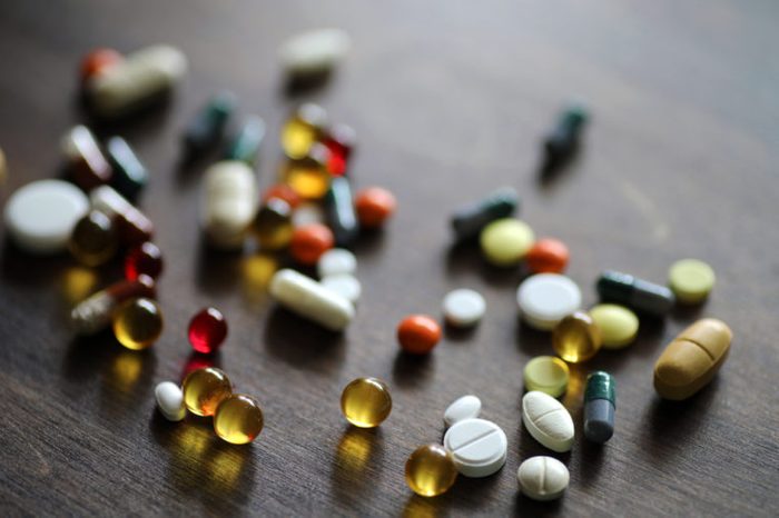 Different colored medications and tablets on a wooden texture table