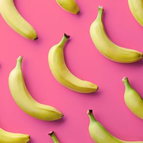 Colorful fruit pattern of fresh yellow bananas on pink background. From top view