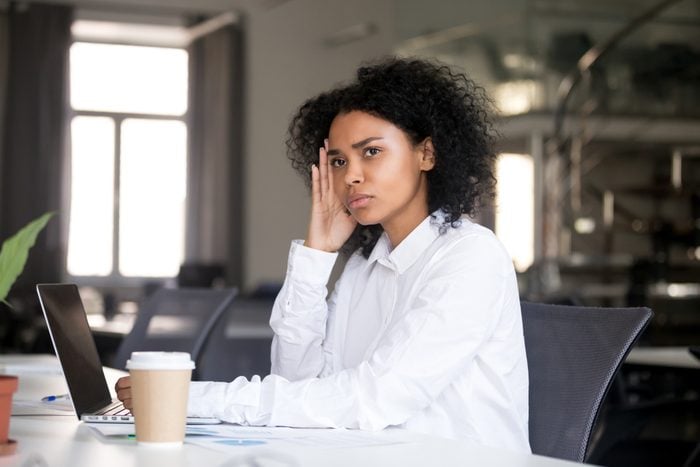Серьезная вдумчивая африканская деловая женщина, сидящая за офисным столом с ноутбуком, отводящая взгляд, думая о решении проблемы, задумчивая чернокожая женщина-миллениал, ищущая новую идею на работе, погруженная в мысли