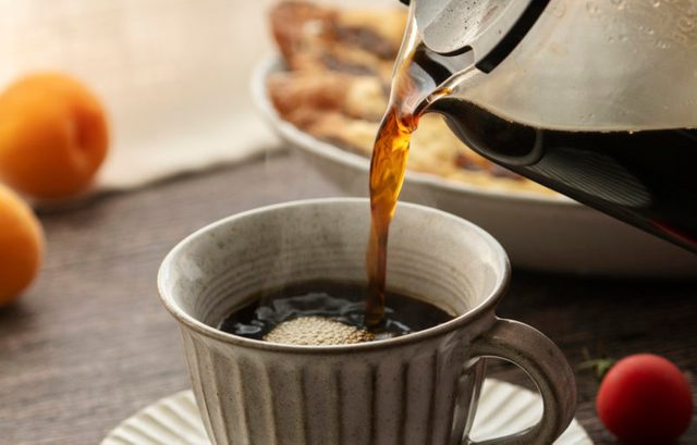 close up of pouring hot coffee into mug