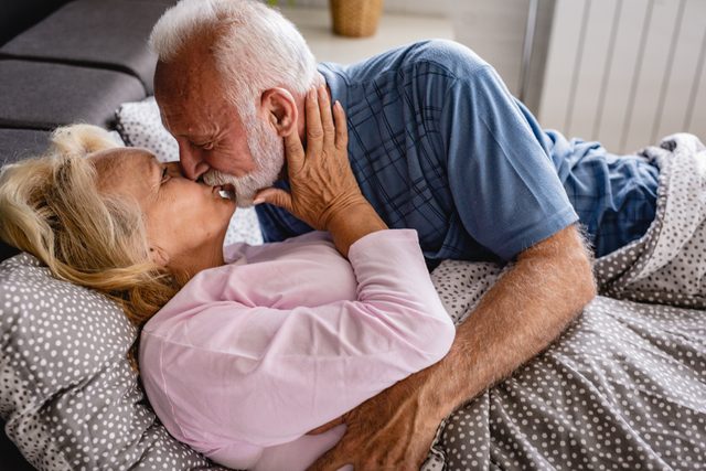 senior couple in bed kissing