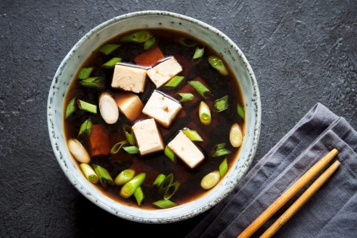 Japanese miso soup in ceramic bowl on dark background, copy space. Asian miso soup with tofu.