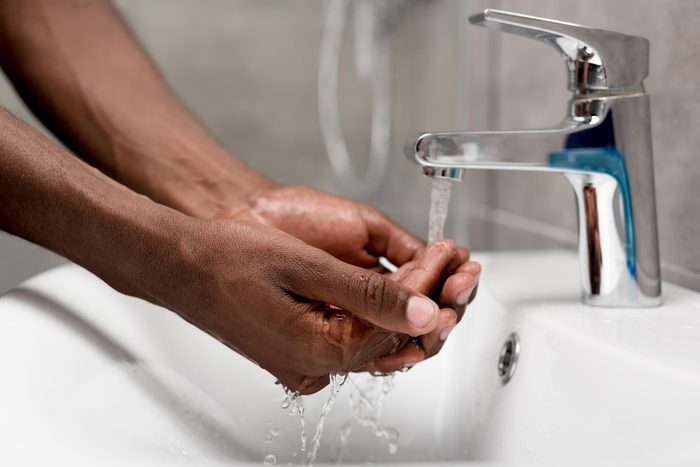 man's hands under the faucet