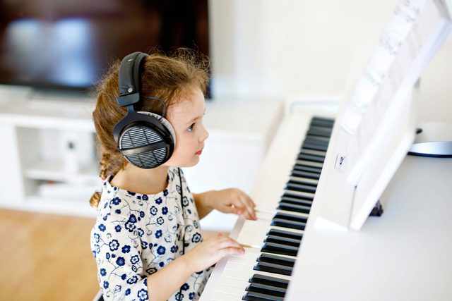 little girl playing keyboard piano