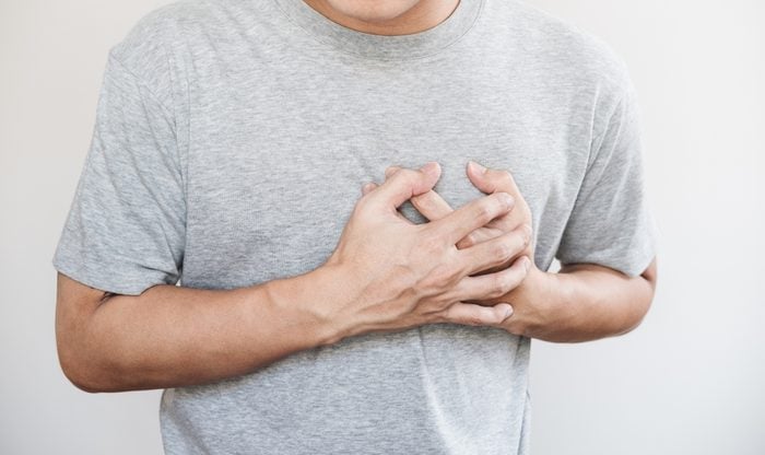 cropped shot of man holding his chest from pain