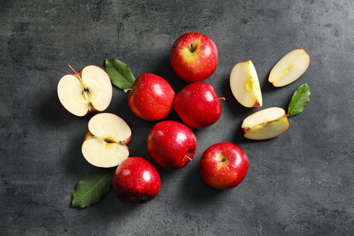 Whole, halved, and quartered red apples
