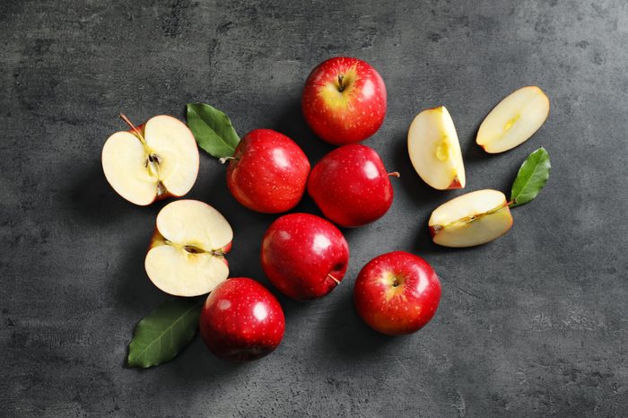 Fresh ripe red apples on grey background, top view