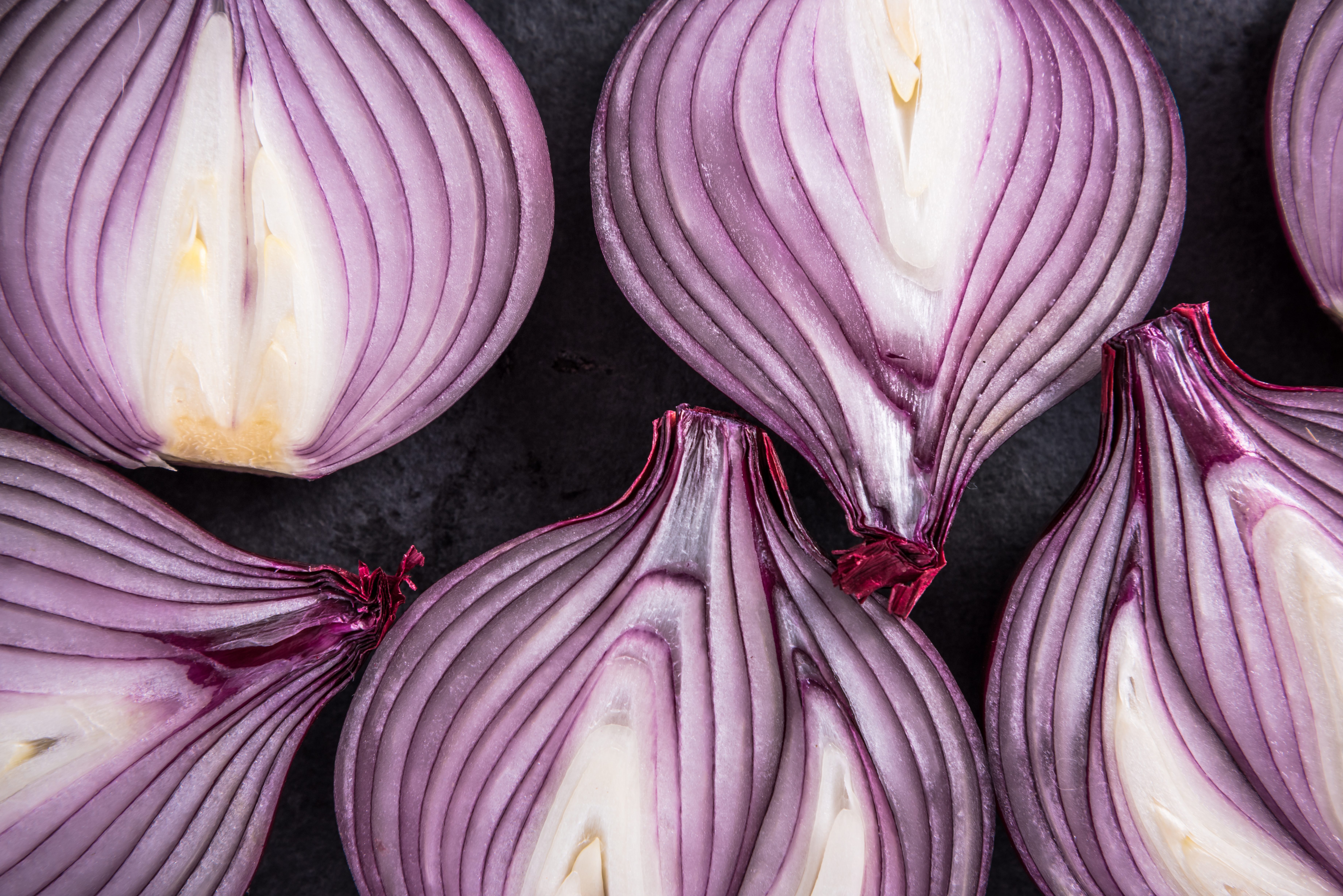 Red onion halves, texture details and pattern, flat lay from above