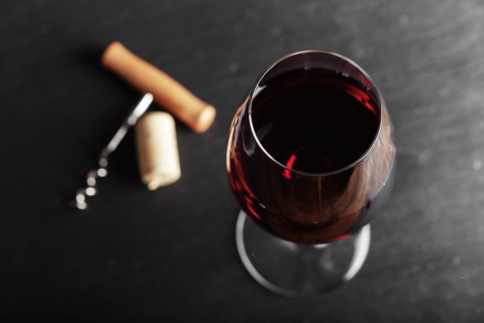 wine glass of red wine with a corkscrew