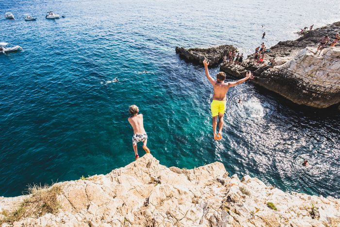 Two children diving from a cliff