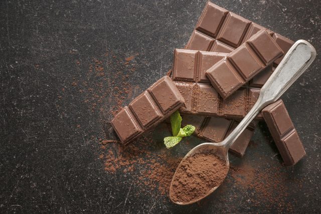 Spoon with cocoa powder and chocolate squares