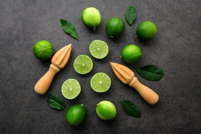Fresh limes and wooden juicer