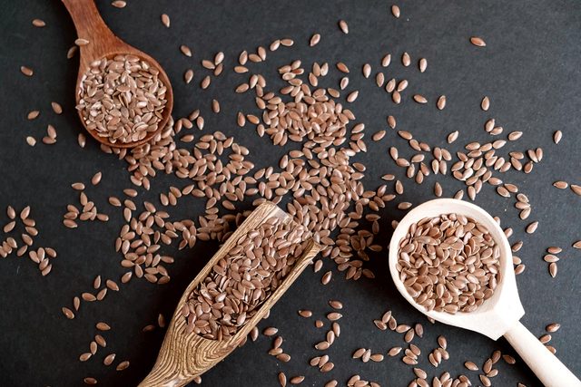 flaxseeds in spoons and on table