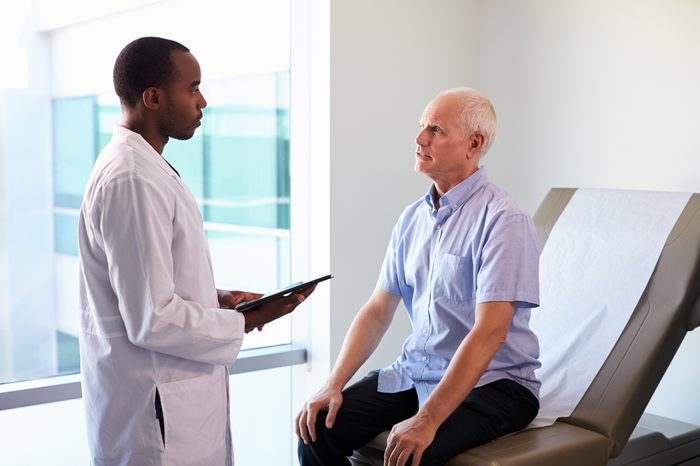 Doctor Meeting With Mature Male Patient In Exam Room