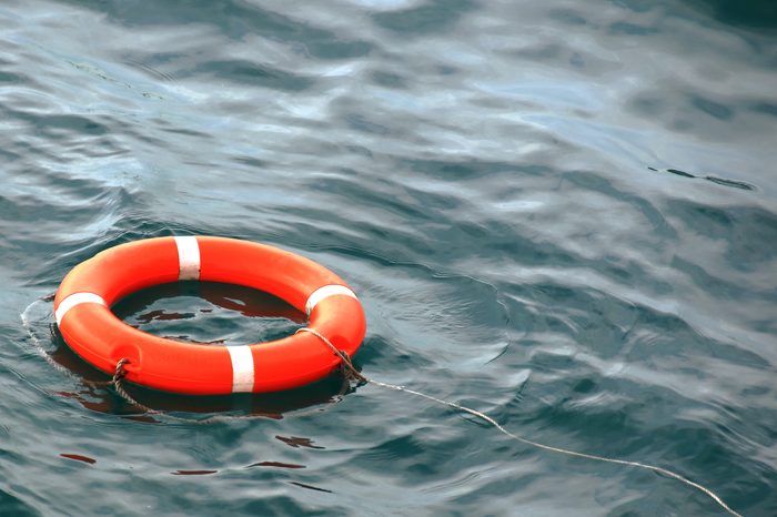 orange life buoy on the waves as a symbol of help and hope