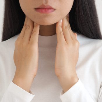 thyroid gland,hyperthyroidism and tonsillolith or tonsil stones and laryngeal cancer in asian woman. She use hand touching neck on isolated white background using for health care concept.