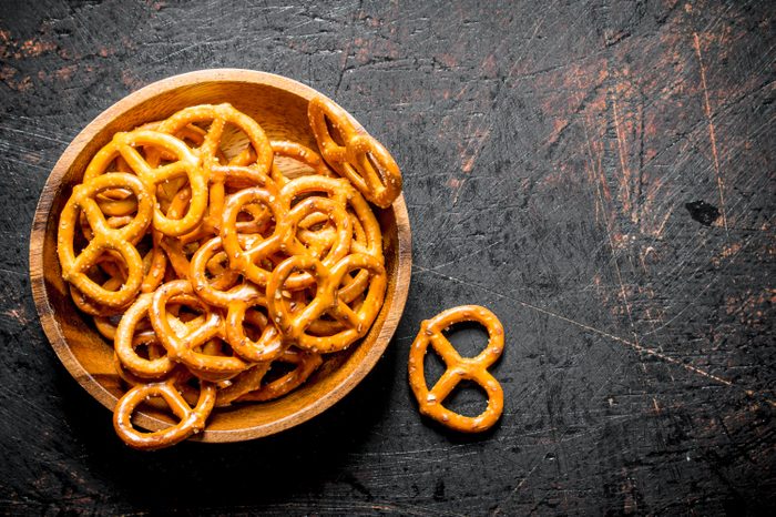 Snacks pretzels in a bowl. On dark rustic background