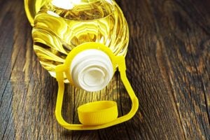Vegetable oil in plastic bottle on old wooden table closeup