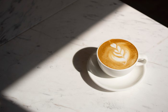 cappuccino coffee on table with sun shining