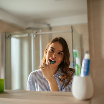 young woman brushing her teeth